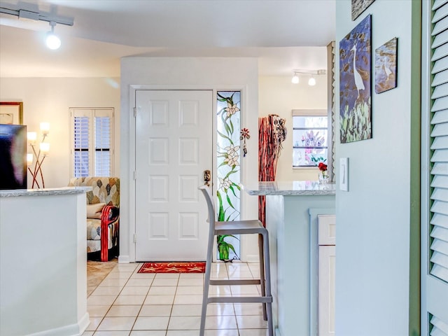 foyer entrance with track lighting and light tile patterned flooring