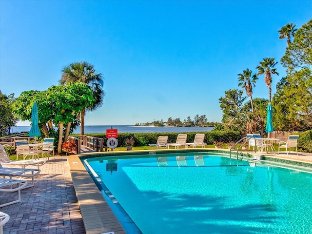 view of pool with a patio and a water view