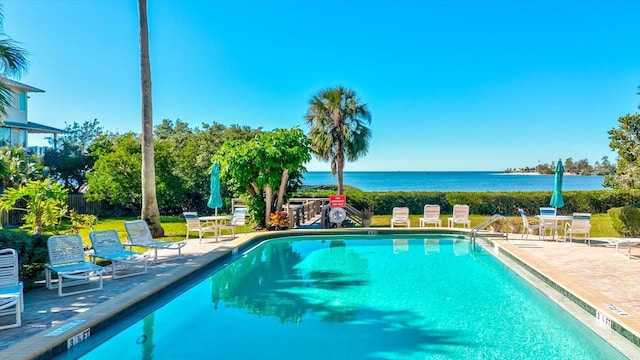 view of swimming pool with a patio area and a water view