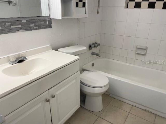 full bathroom with tile patterned floors, vanity, toilet, and tiled shower / bath