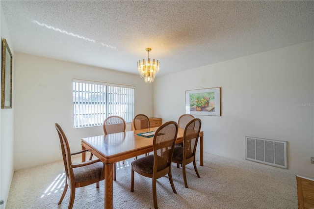 dining room featuring an inviting chandelier and a textured ceiling