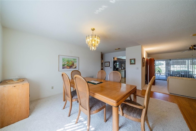 dining space featuring ceiling fan with notable chandelier and light hardwood / wood-style flooring