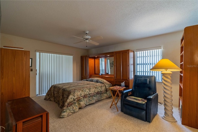 carpeted bedroom with a textured ceiling and ceiling fan