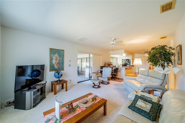 carpeted living room with a textured ceiling and ceiling fan