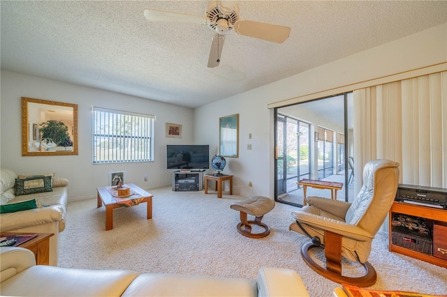 carpeted living room with ceiling fan and a textured ceiling