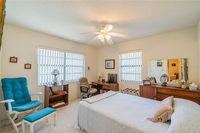 bedroom with light colored carpet, a textured ceiling, and ceiling fan