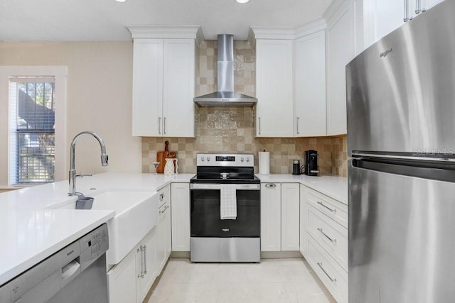 kitchen featuring white cabinetry, backsplash, wall chimney exhaust hood, and appliances with stainless steel finishes