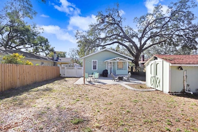 back of house with a patio and a shed