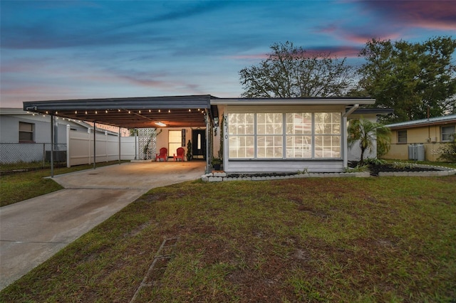 view of front of house featuring a carport and a yard