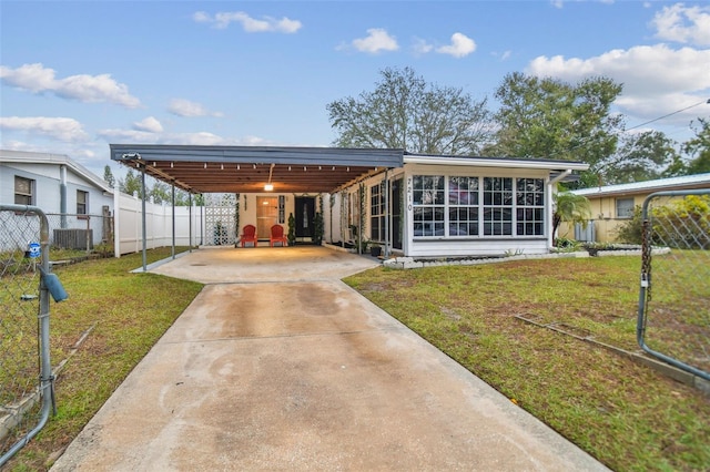 view of front of house with a front yard, a carport, and a sunroom