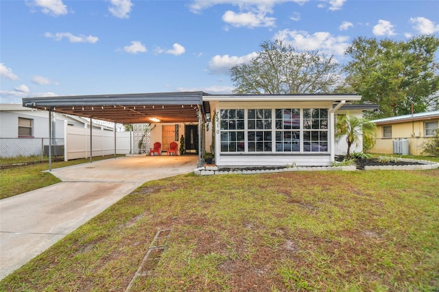 back of property featuring a lawn and a carport