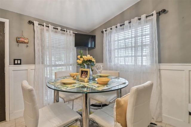 dining room with lofted ceiling and light tile patterned floors