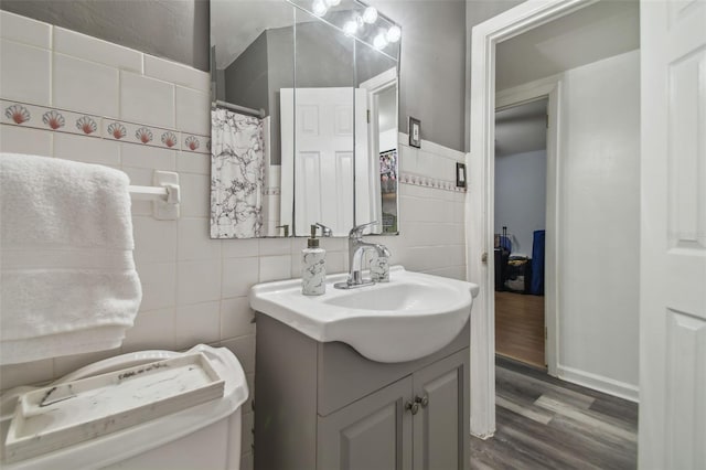 bathroom with vanity, hardwood / wood-style flooring, and tile walls