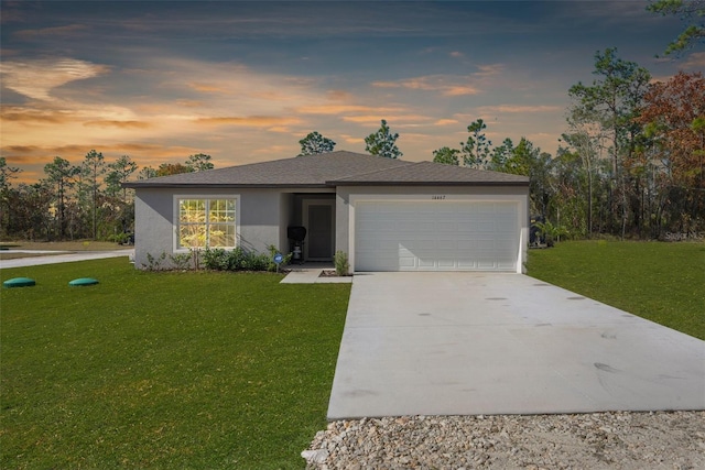 single story home with a garage and a lawn