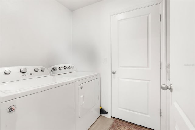 laundry area featuring light tile patterned flooring and washing machine and dryer