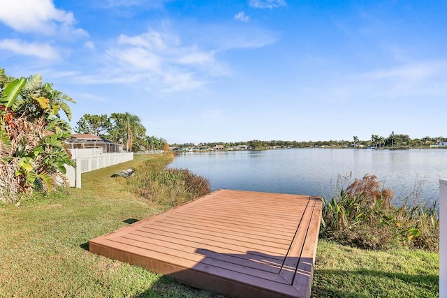 view of dock featuring a lawn and a water view