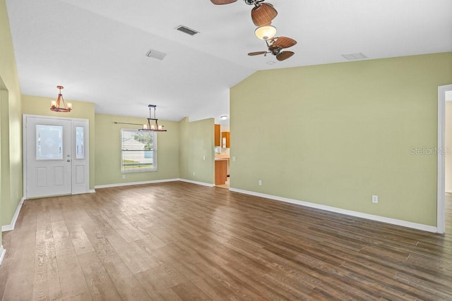 unfurnished living room featuring hardwood / wood-style floors, ceiling fan with notable chandelier, and vaulted ceiling