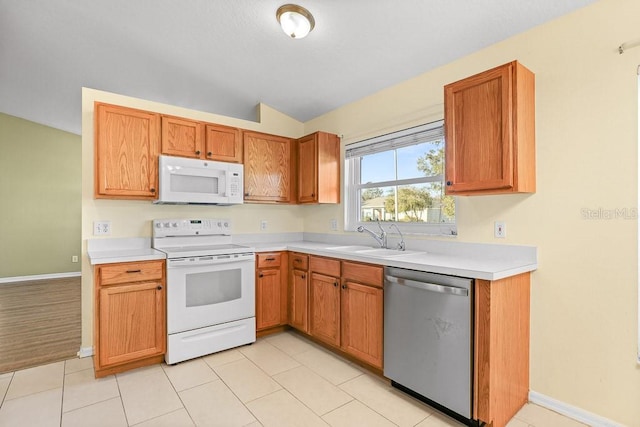 kitchen with white appliances, sink, light tile patterned floors, and vaulted ceiling