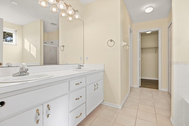 bathroom with tile patterned flooring, vanity, and a shower with door