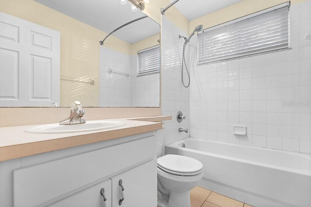 full bathroom featuring tile patterned floors, vanity, tiled shower / bath, and toilet