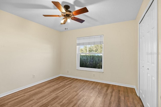 unfurnished bedroom with hardwood / wood-style floors, a closet, and ceiling fan