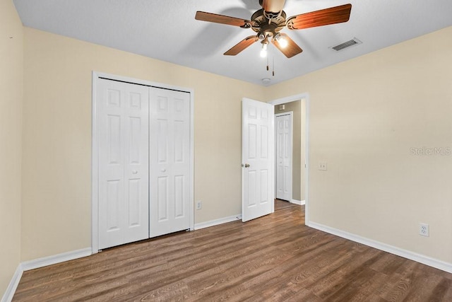 unfurnished bedroom featuring ceiling fan, a closet, and hardwood / wood-style flooring