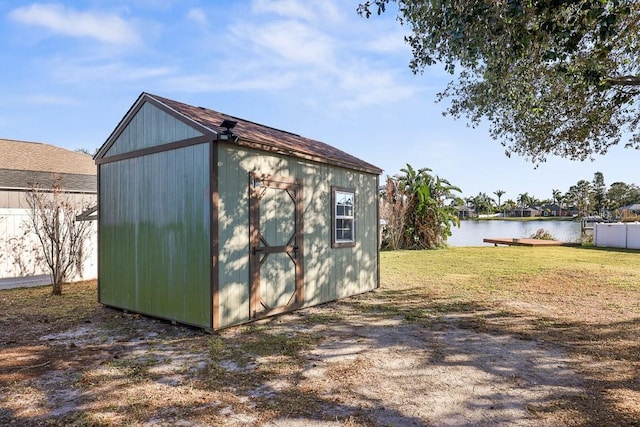 view of outbuilding featuring a water view and a yard