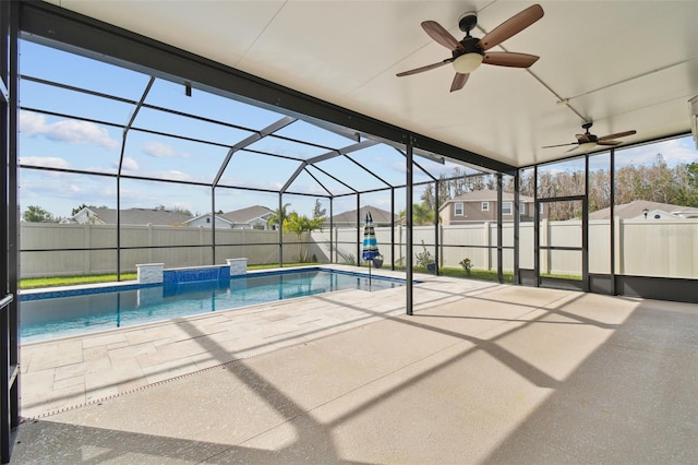 view of pool with glass enclosure and a patio area