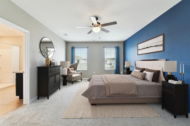 bedroom featuring carpet flooring, ensuite bathroom, and ceiling fan