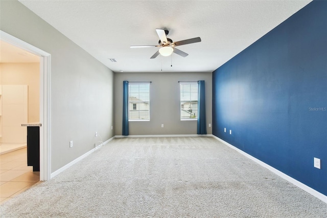 carpeted spare room featuring ceiling fan