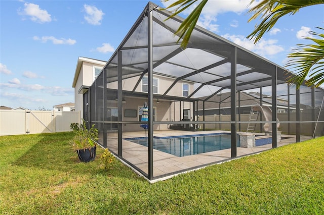 view of pool with a patio, glass enclosure, and a lawn