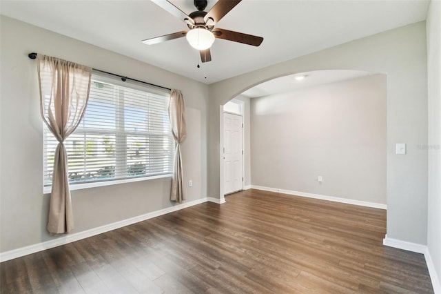 empty room with dark hardwood / wood-style floors and ceiling fan