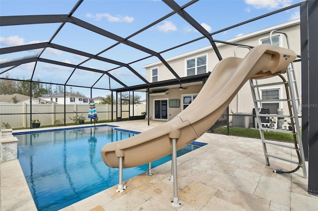 view of pool featuring glass enclosure, a patio, a water slide, and central AC