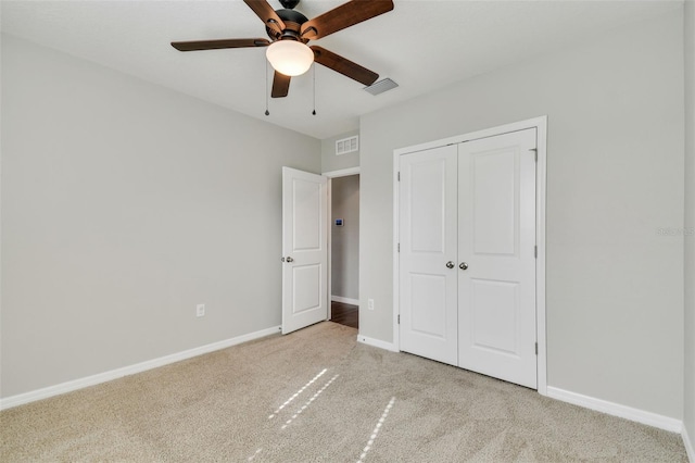 unfurnished bedroom with a closet, ceiling fan, and light colored carpet