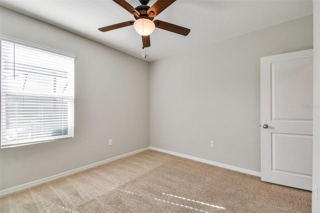 empty room with ceiling fan and light colored carpet