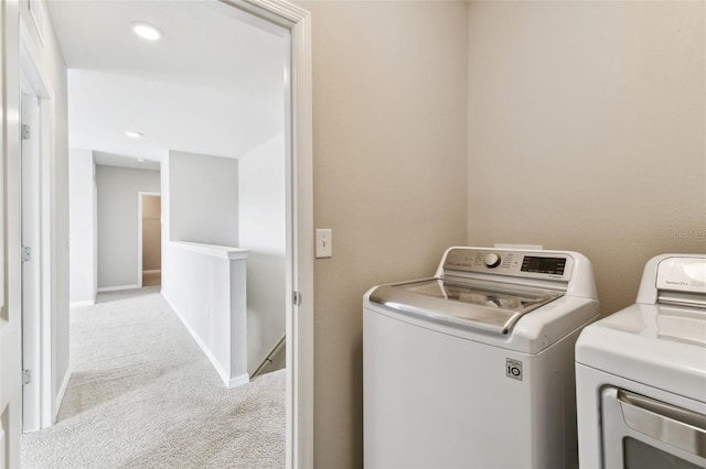 laundry room featuring separate washer and dryer and light carpet