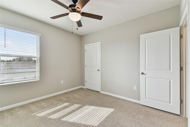 unfurnished bedroom with ceiling fan and light colored carpet