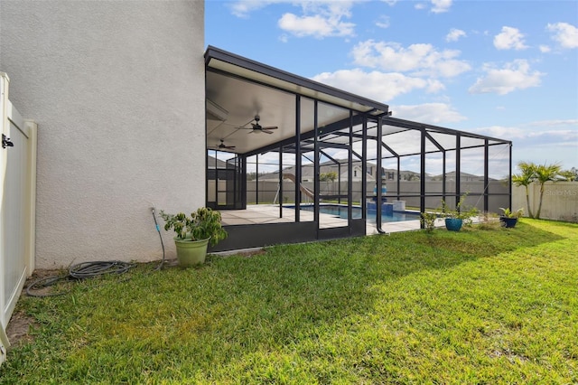 view of yard with a lanai, ceiling fan, a patio area, and a fenced in pool