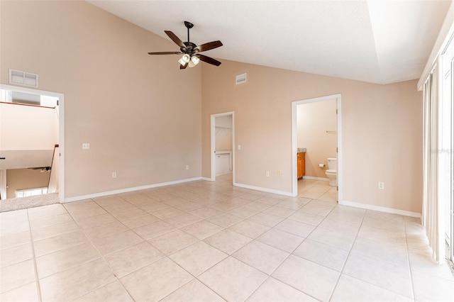 unfurnished bedroom featuring light tile patterned floors, a walk in closet, a closet, ensuite bathroom, and ceiling fan