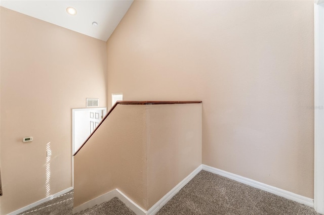 staircase featuring carpet and lofted ceiling