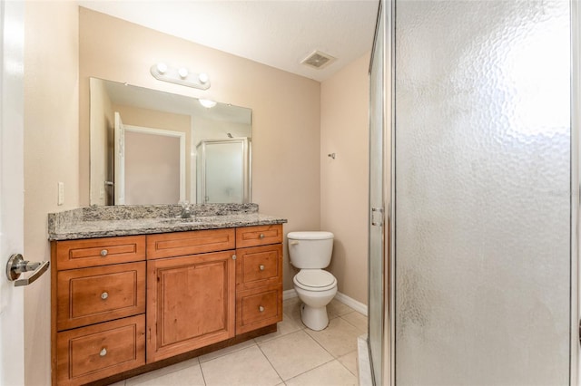 bathroom with tile patterned floors, a shower with shower door, toilet, and vanity