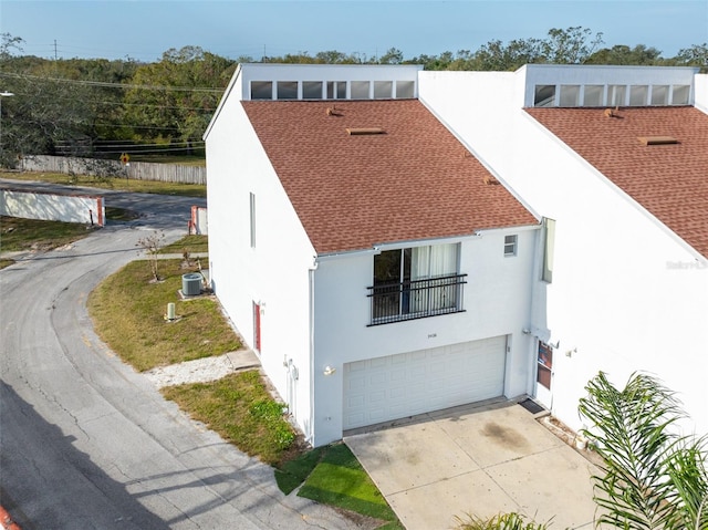 view of front facade featuring a garage and central air condition unit