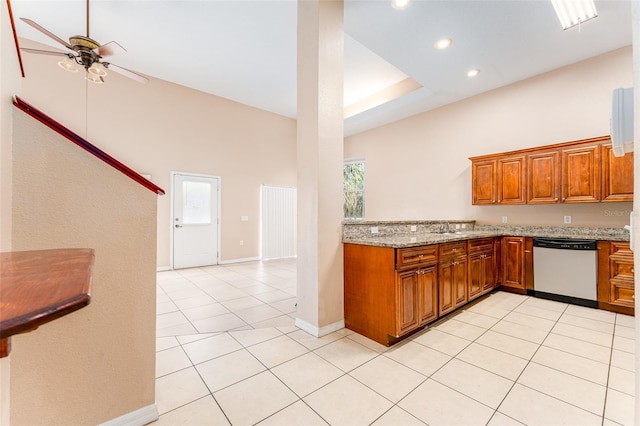 kitchen featuring light tile patterned floors, light stone counters, a towering ceiling, ceiling fan, and stainless steel dishwasher