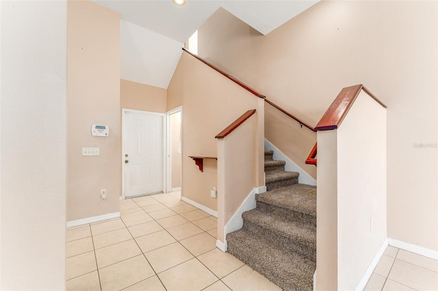 staircase featuring vaulted ceiling and tile patterned flooring