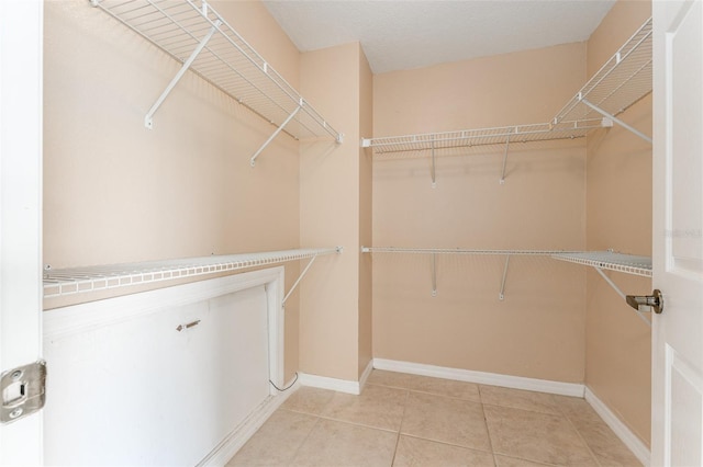 walk in closet with light tile patterned floors