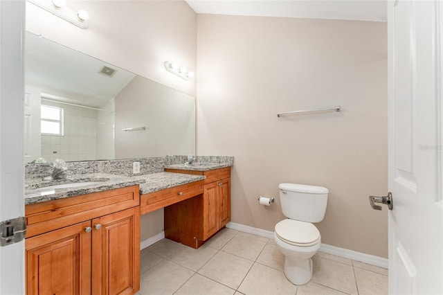 bathroom featuring tile patterned floors, toilet, vanity, and walk in shower