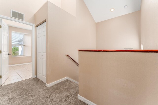 stairway with vaulted ceiling and carpet