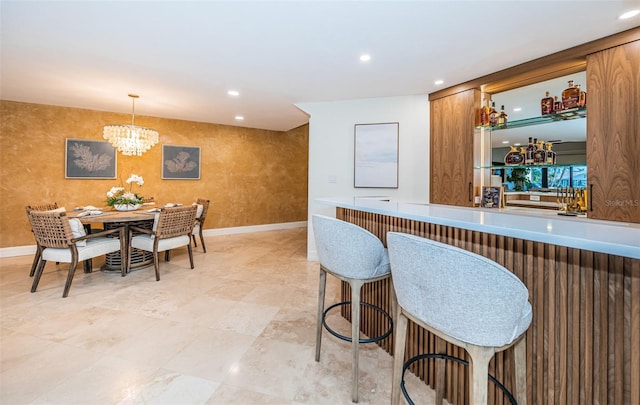 kitchen with a breakfast bar area, a notable chandelier, and decorative light fixtures