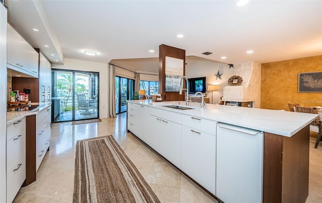 kitchen featuring sink, a kitchen island with sink, and white cabinets