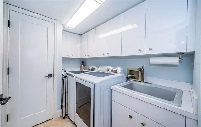 washroom featuring cabinets, washer and clothes dryer, sink, and light tile patterned floors